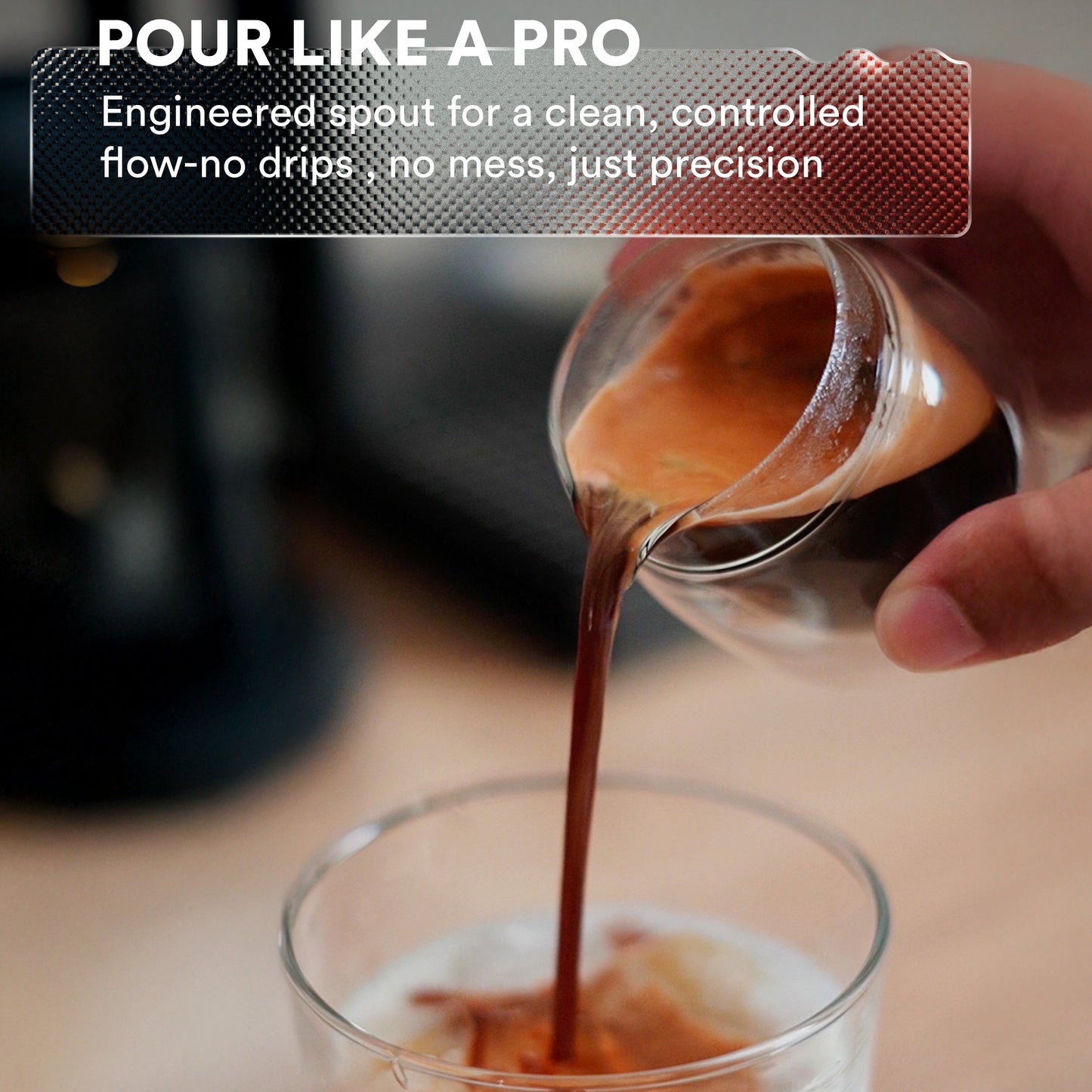 Hand pouring coffee from a container into a glass with text about a engineered spout.