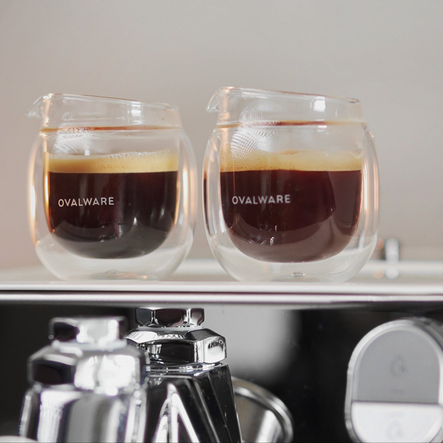 Two coffee cups with coffee inside, placed on a kitchen counter with text about home baristas.