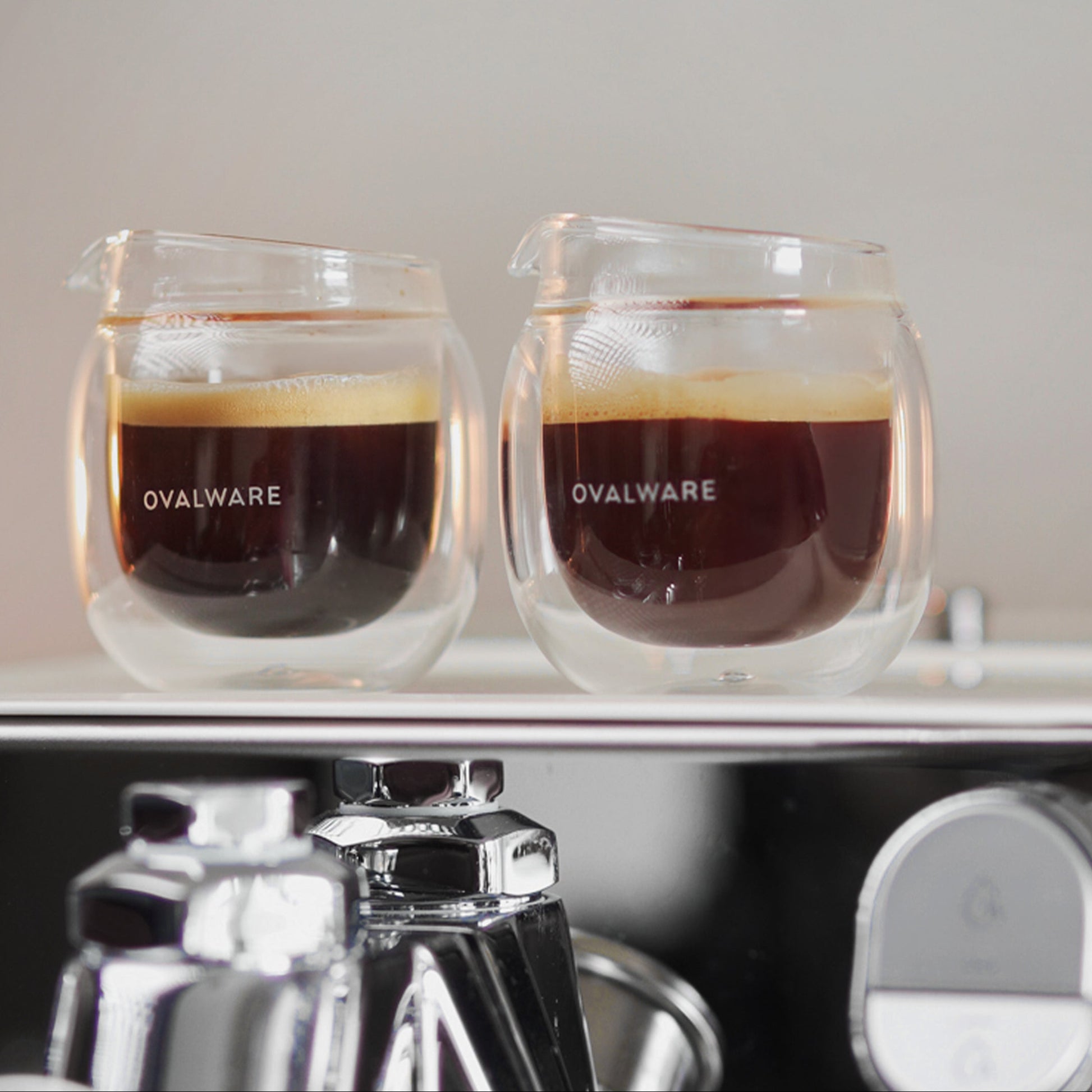 Two coffee cups with coffee inside, placed on a kitchen counter with text about home baristas.